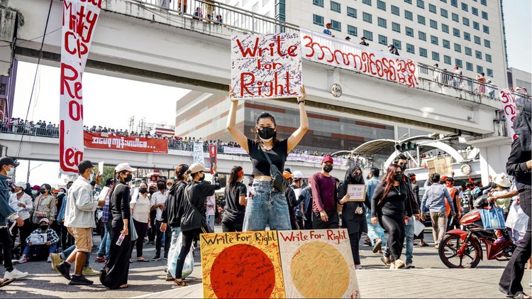 Write for Right |Chuu Wai holding up her art at a protest (© Image Chuu Wai)